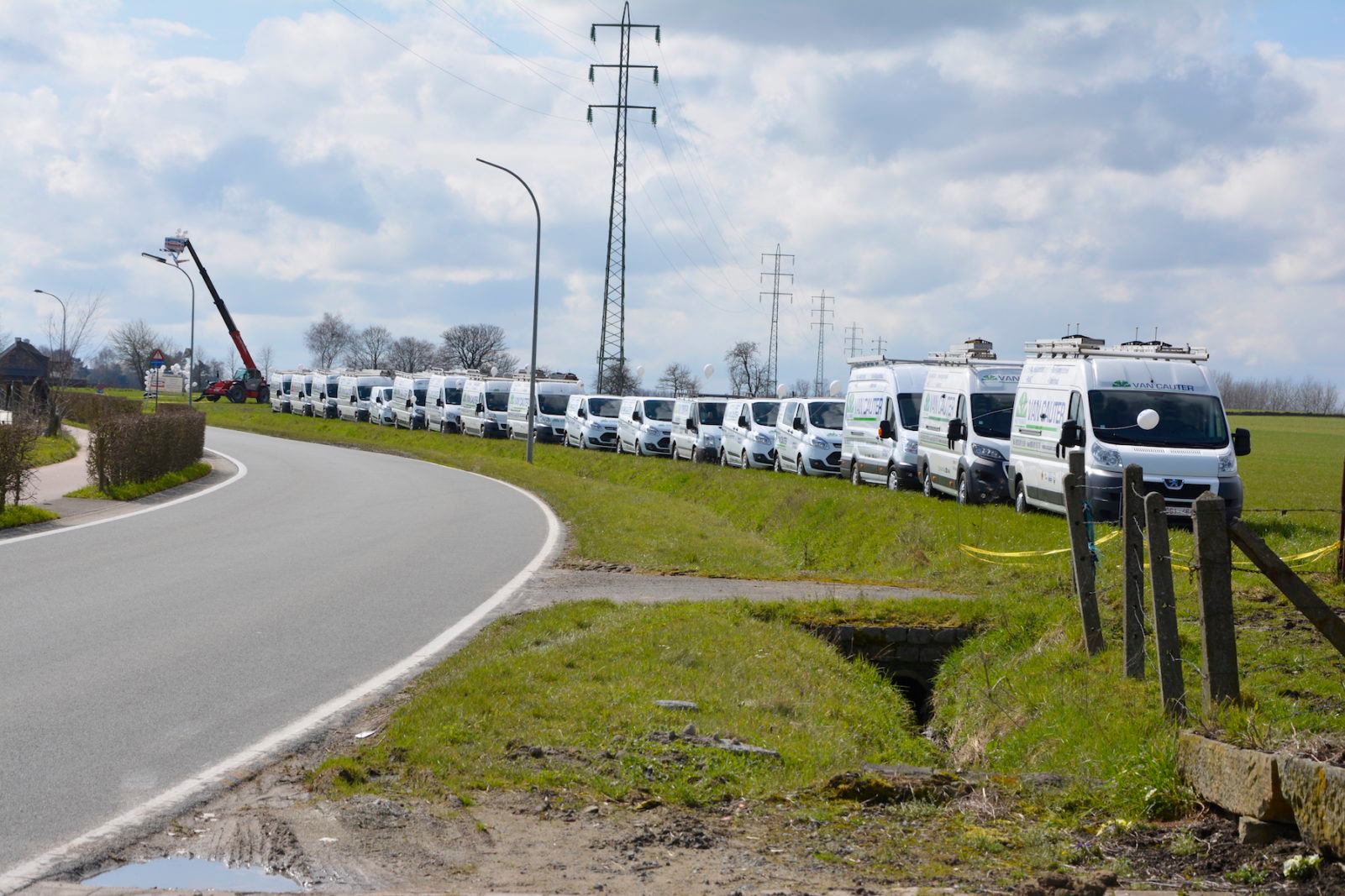 Het wagenpark van Van Cauter Multitechnieken: een lange rij bestelwagens met het logo op de zijkant