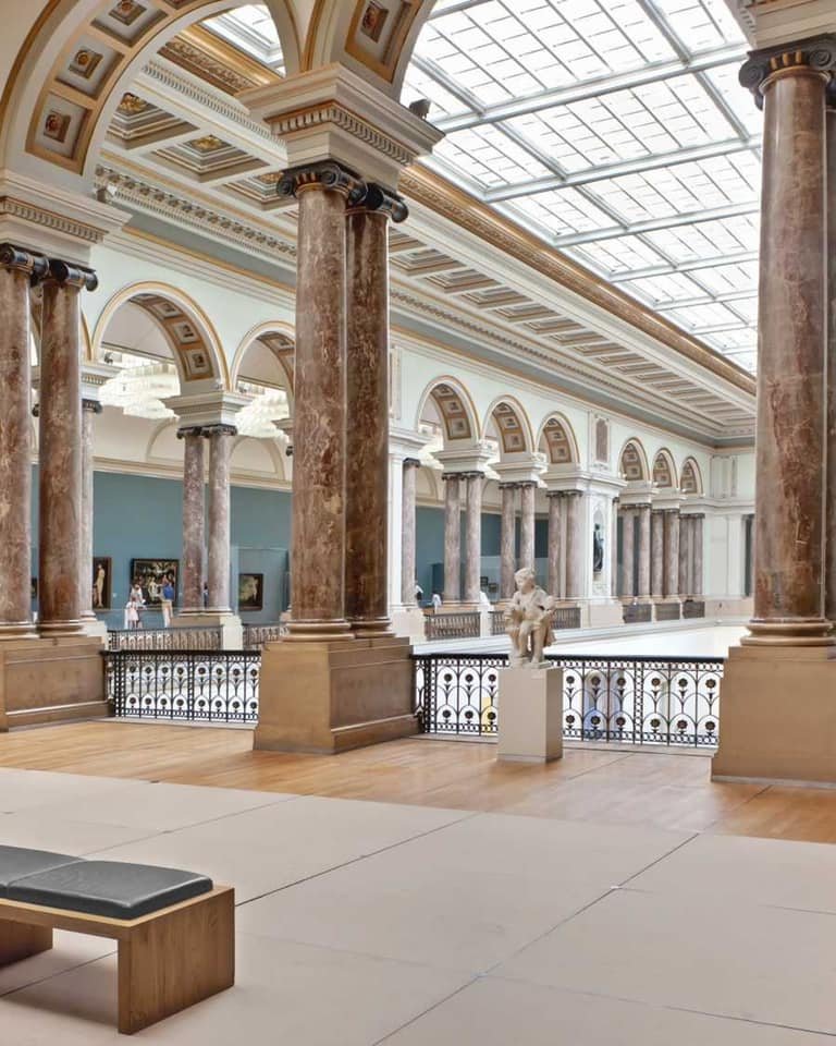 Museumzaal met marmeren zuilen en glazen dak